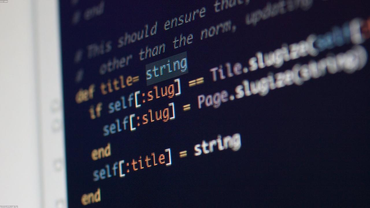 Code editor with autocomplete suggestions on a large monitor.
