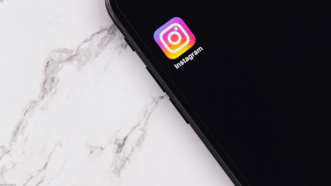 Smartphone displaying a social-media feed against a soft background.